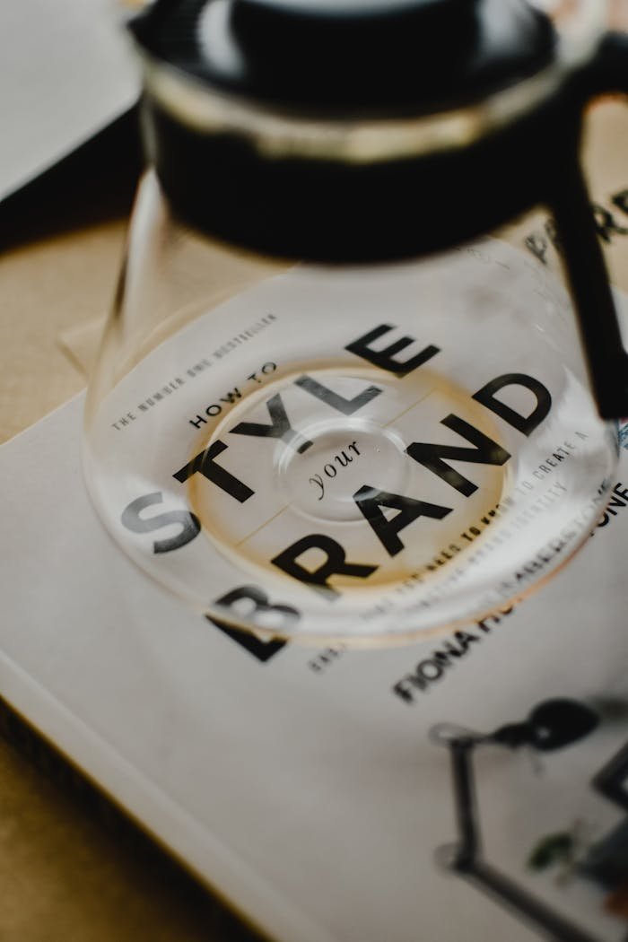 embark A coffee pot rests atop a book titled 'How to Style Your Brand', capturing the essence of creative branding.